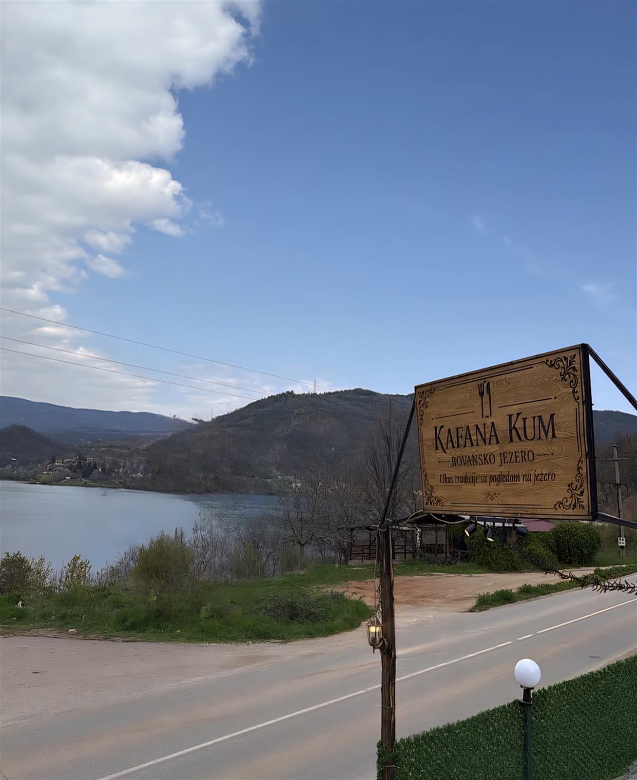 Tabla sa natpisom Kafana Kum na putu pored Bovanskog jezera