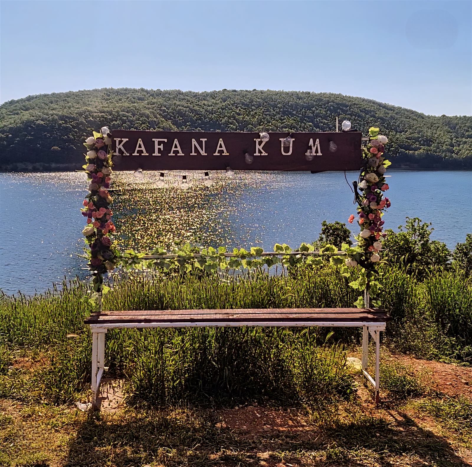 Ukrašena tabla „Kafana Kum” sa pogledom na jezero